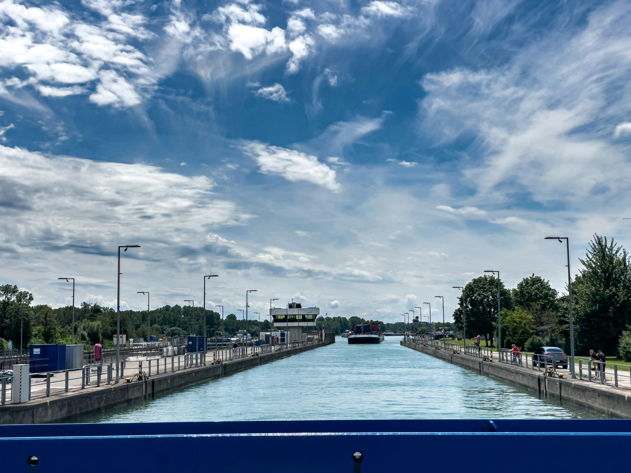 A blue bench sitting on the side of a river