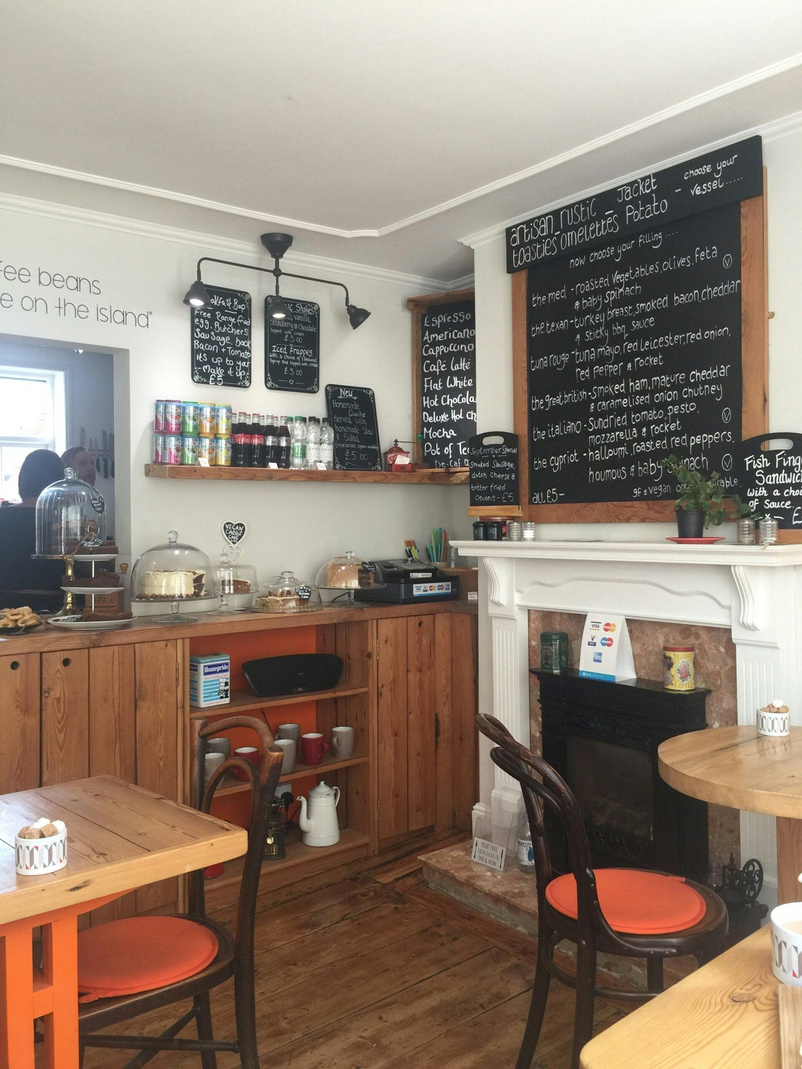 A coffee shop with a fireplace and menus on the wall