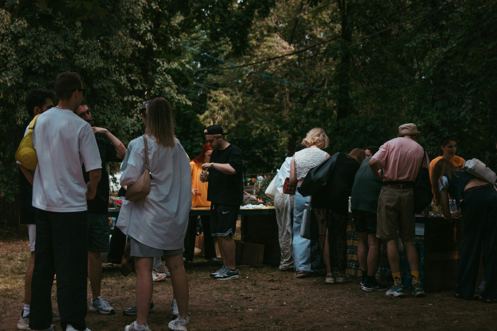 A group of people standing around a table in the woods