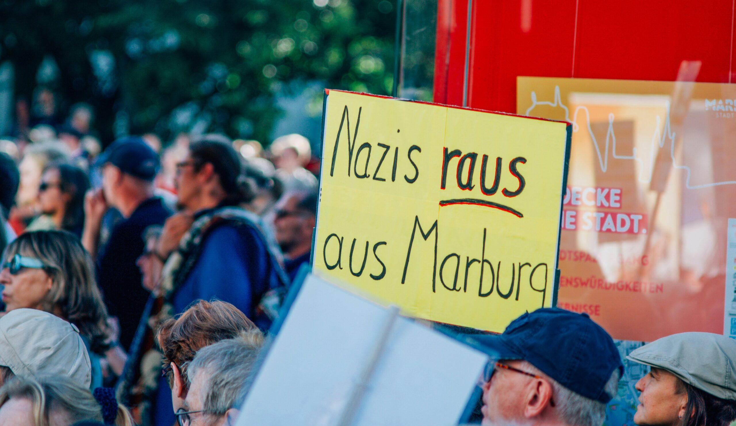 A group of people standing around each other holding signs