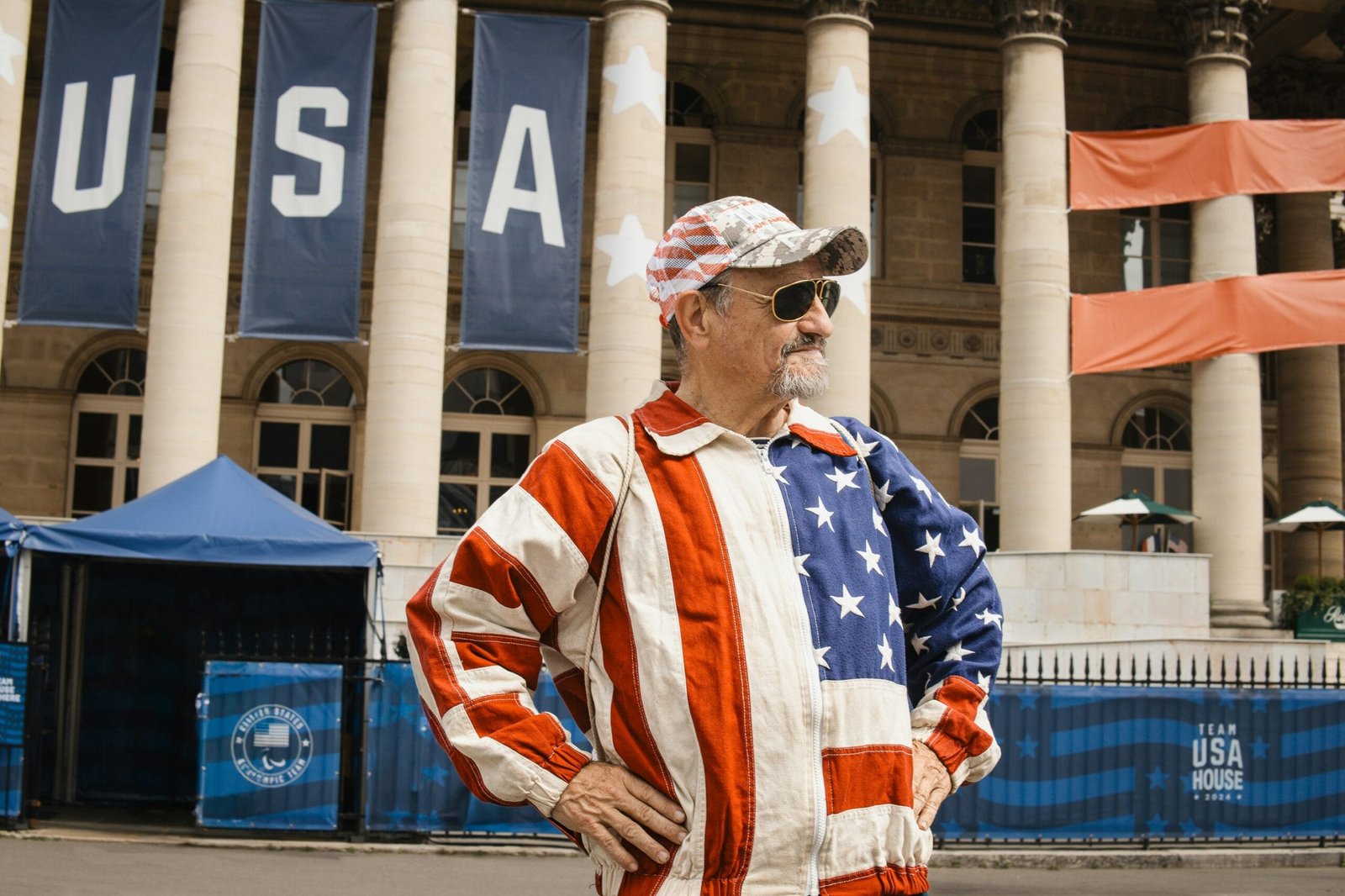 A man standing in front of a building with an american flag on it