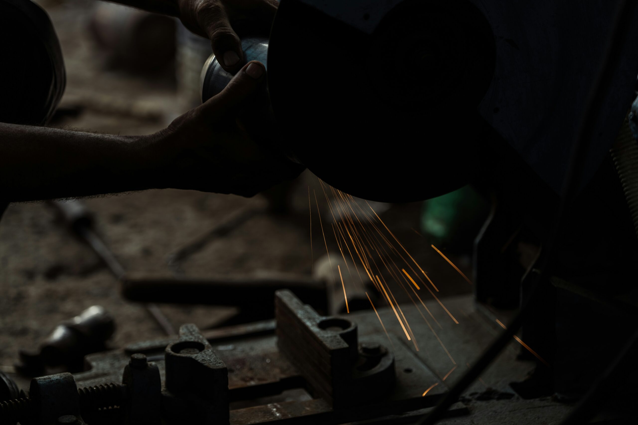 A person using a grinder on a piece of metal