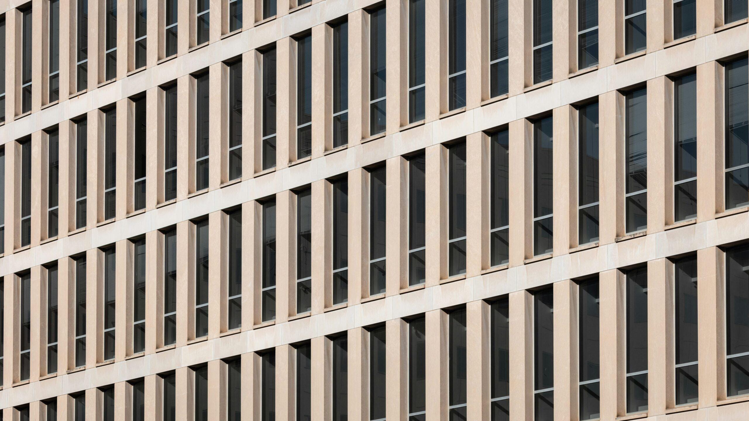 A tall building with lots of windows next to a street sign