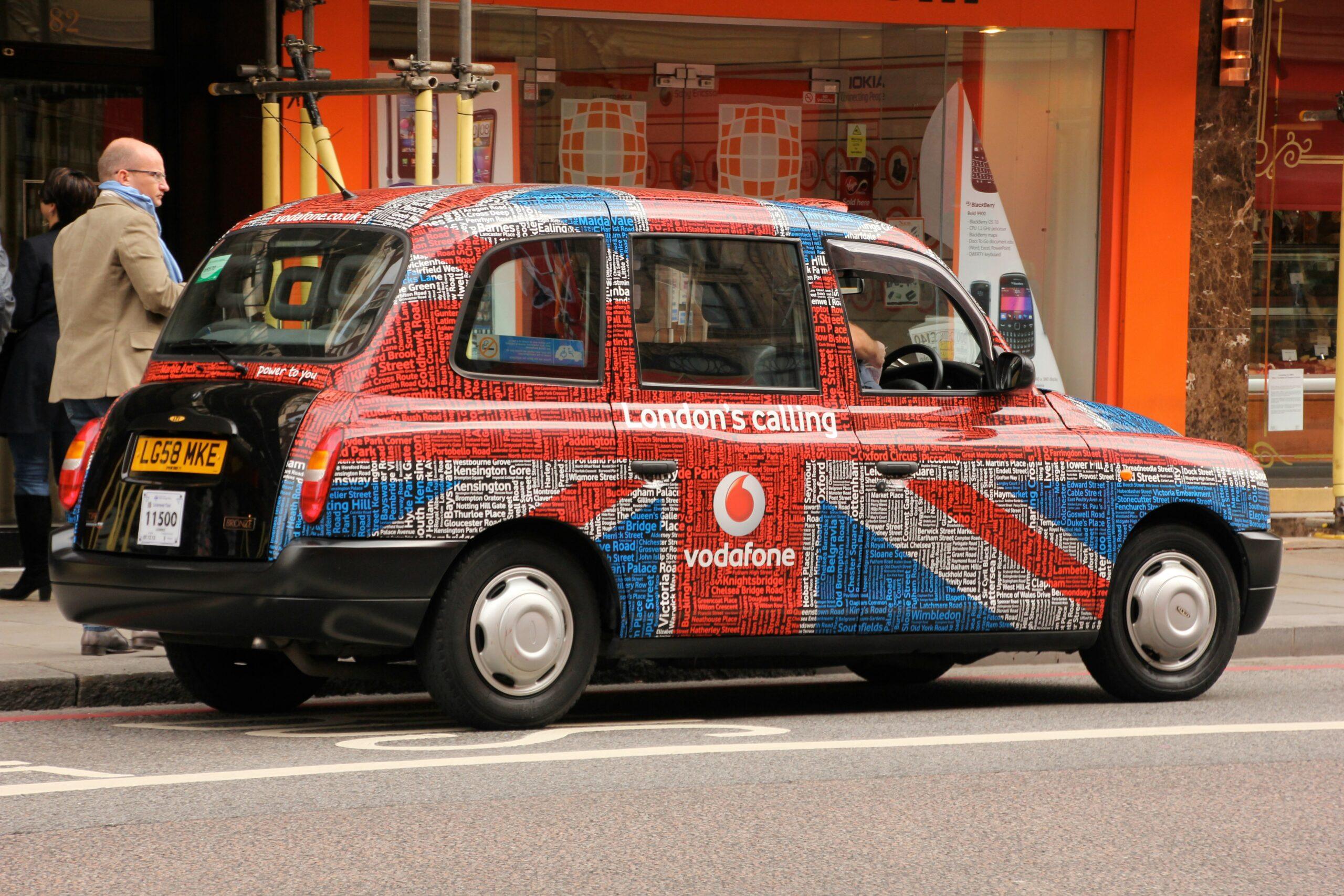 United Kingdon flag-themed 5-door hatchback on gray concrete road