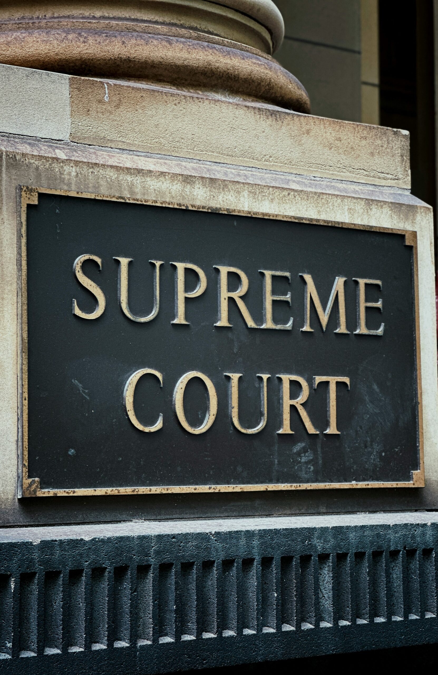 a black and gold sign that says supreme court