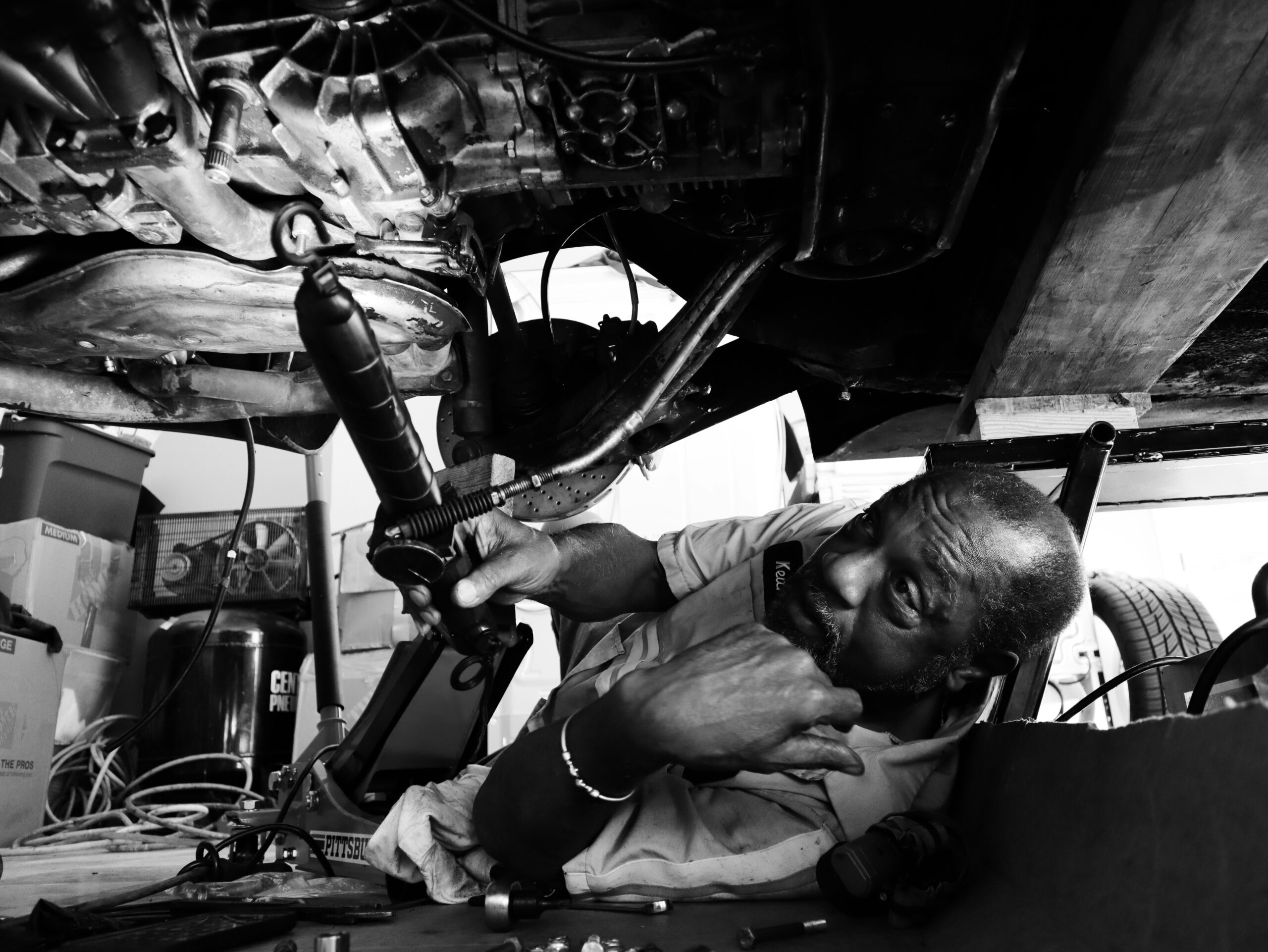 a black and white photo of a man working on a machine