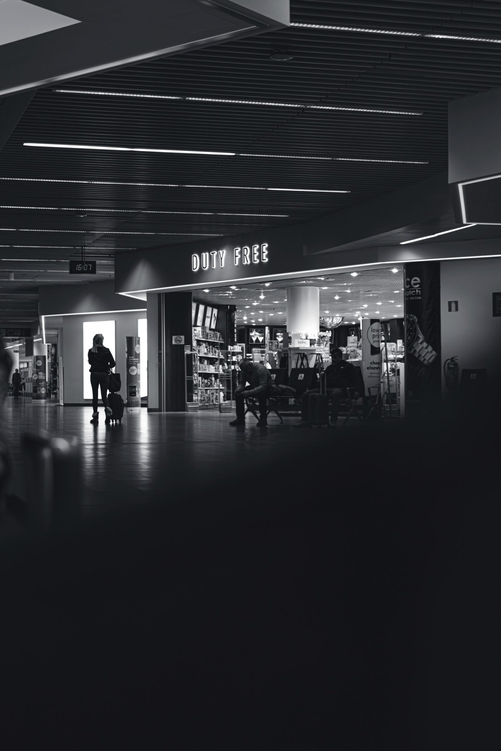 a black and white photo of people walking through an airport