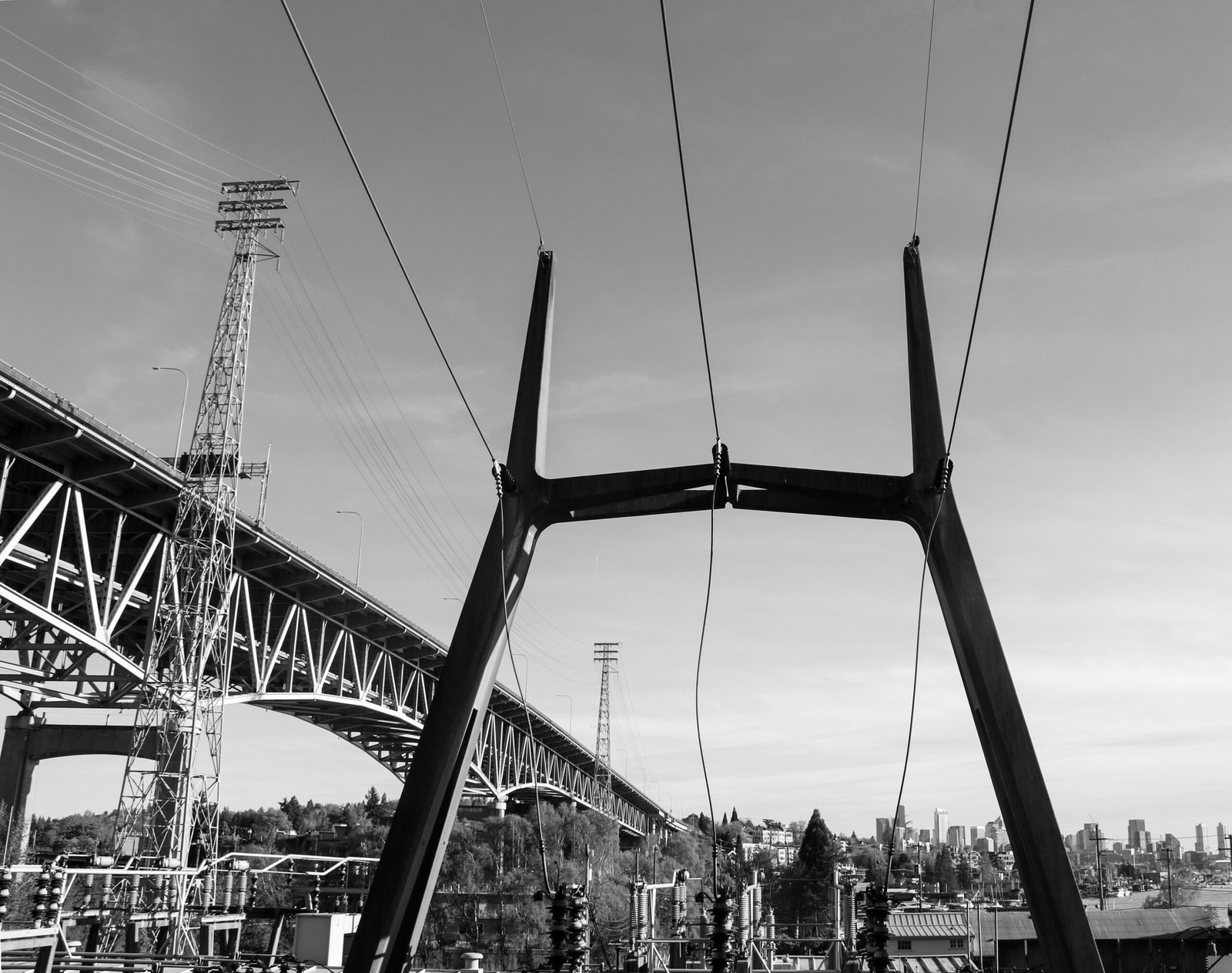 a black and white photo of power lines and a bridge