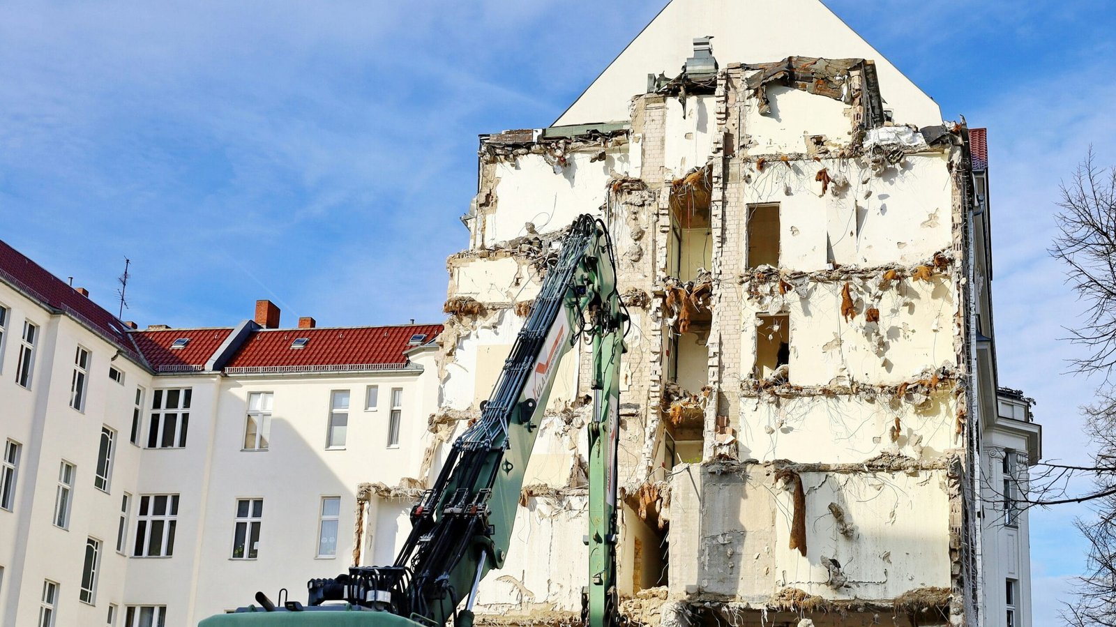 a building being demolished with a crane in front of it