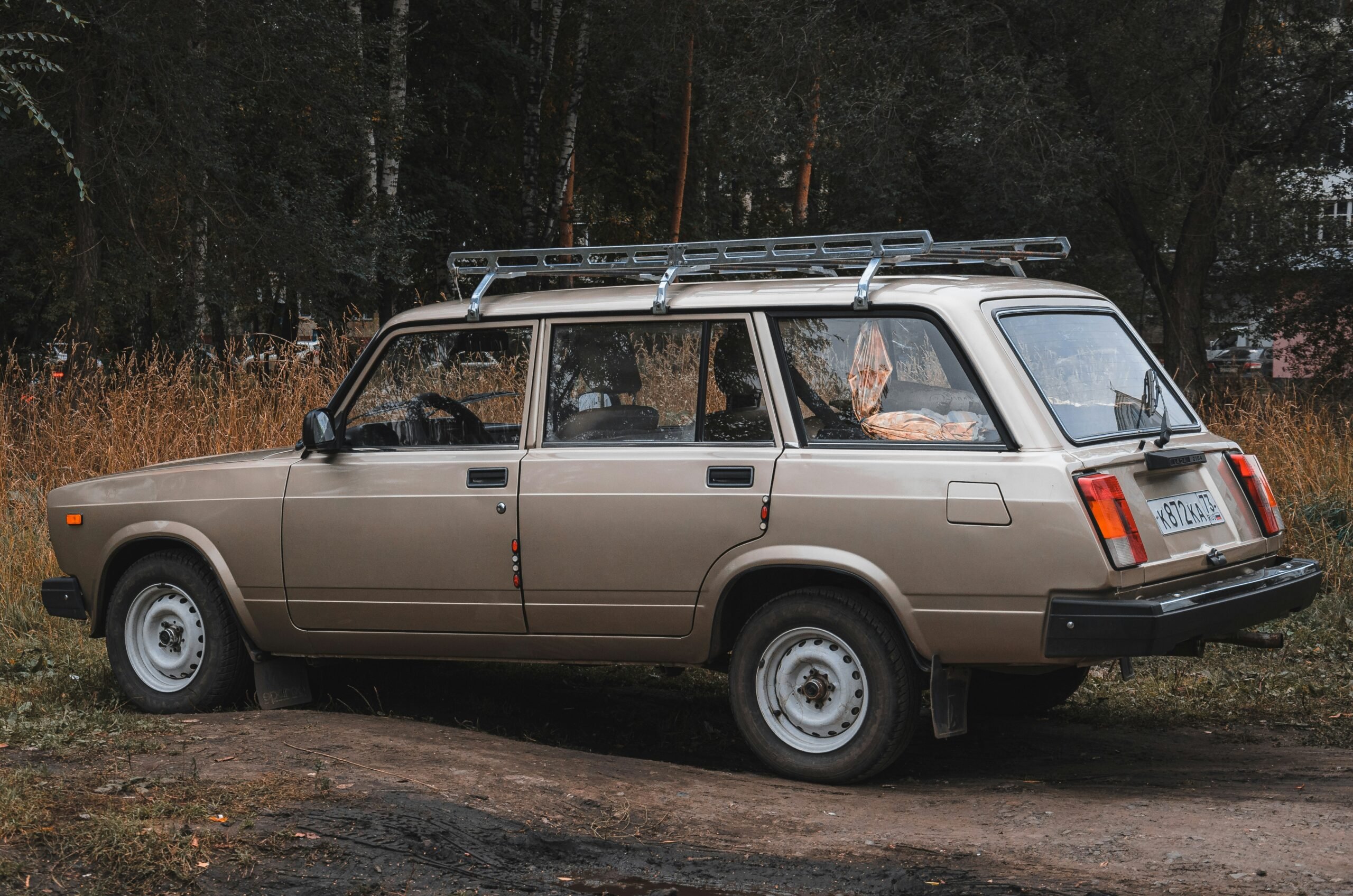 a car parked on a dirt road in a wooded area