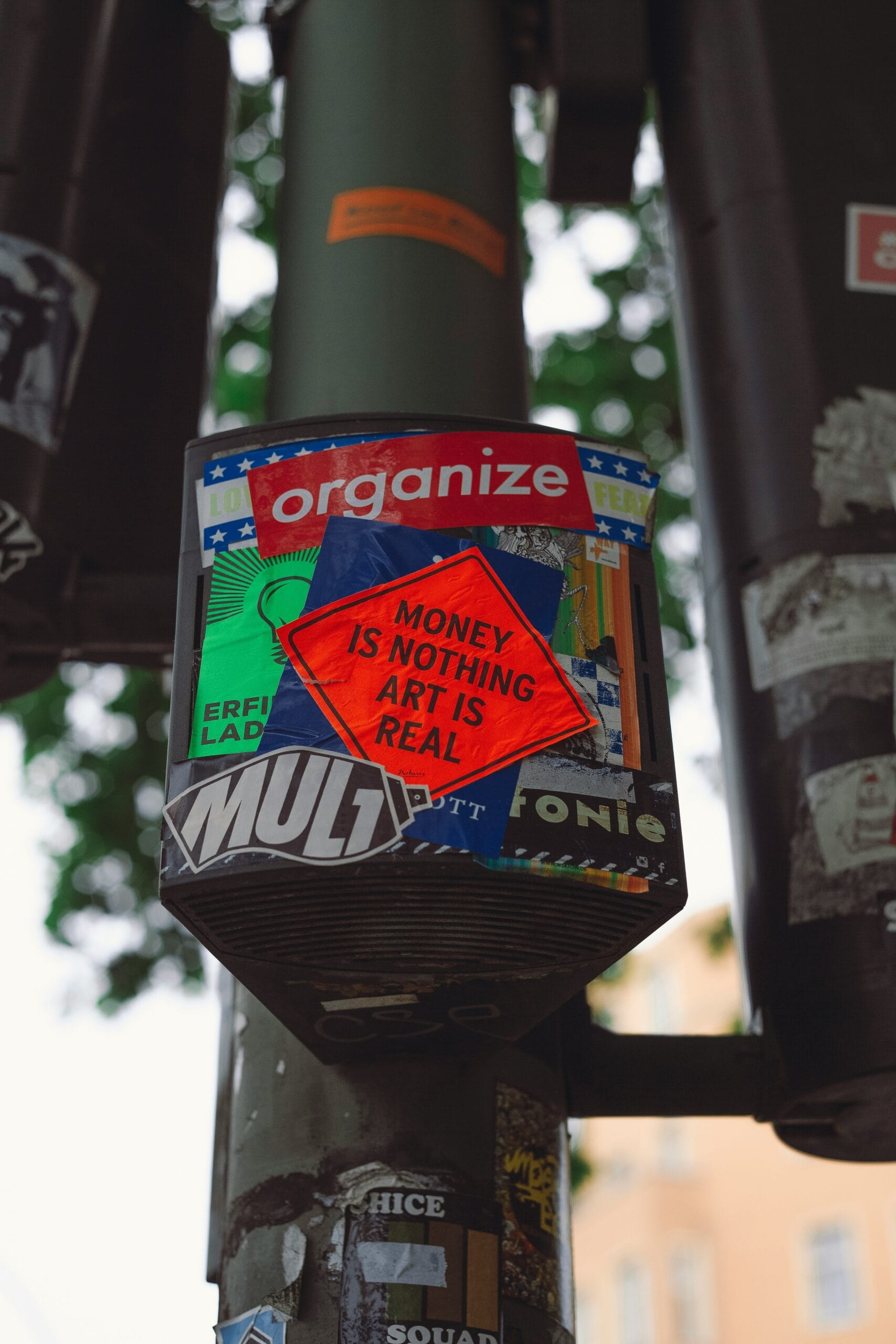 a close up of a street pole with stickers on it