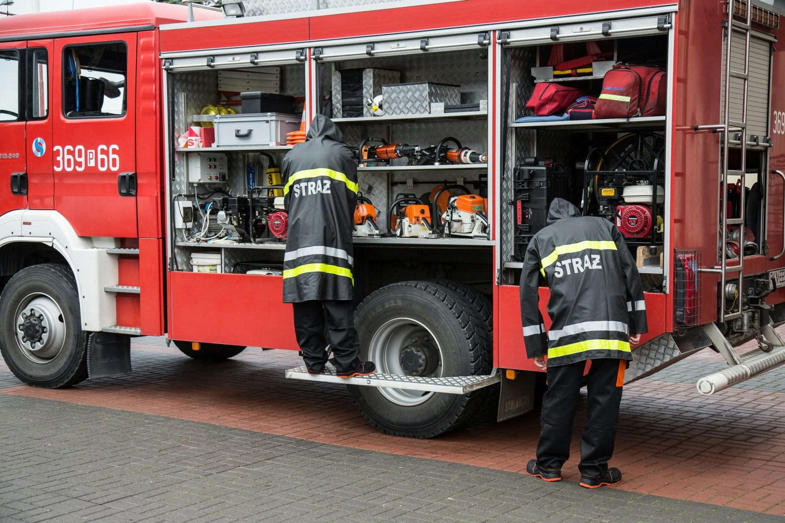 a couple of men standing next to a fire truck