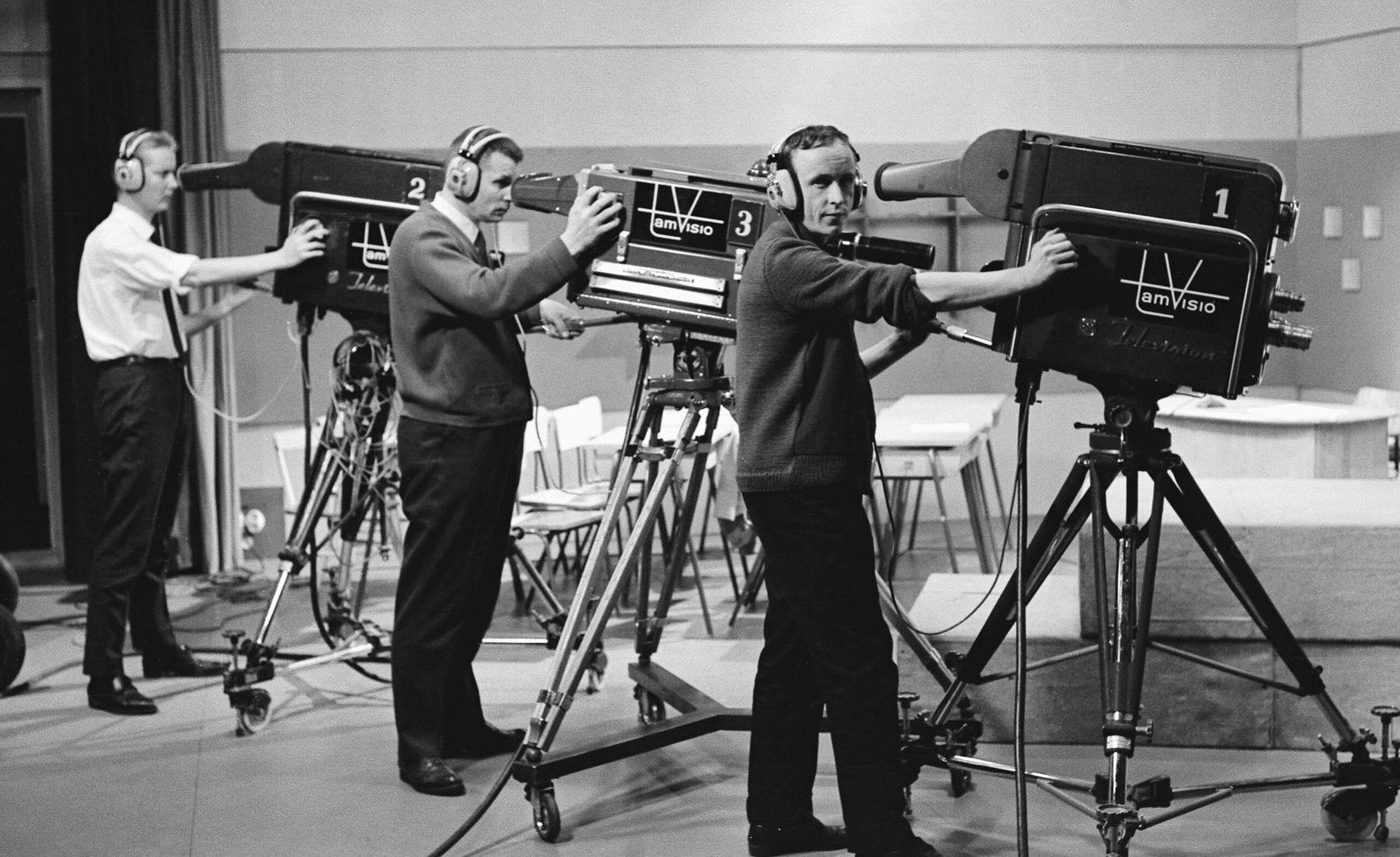 a group of men standing around a camera