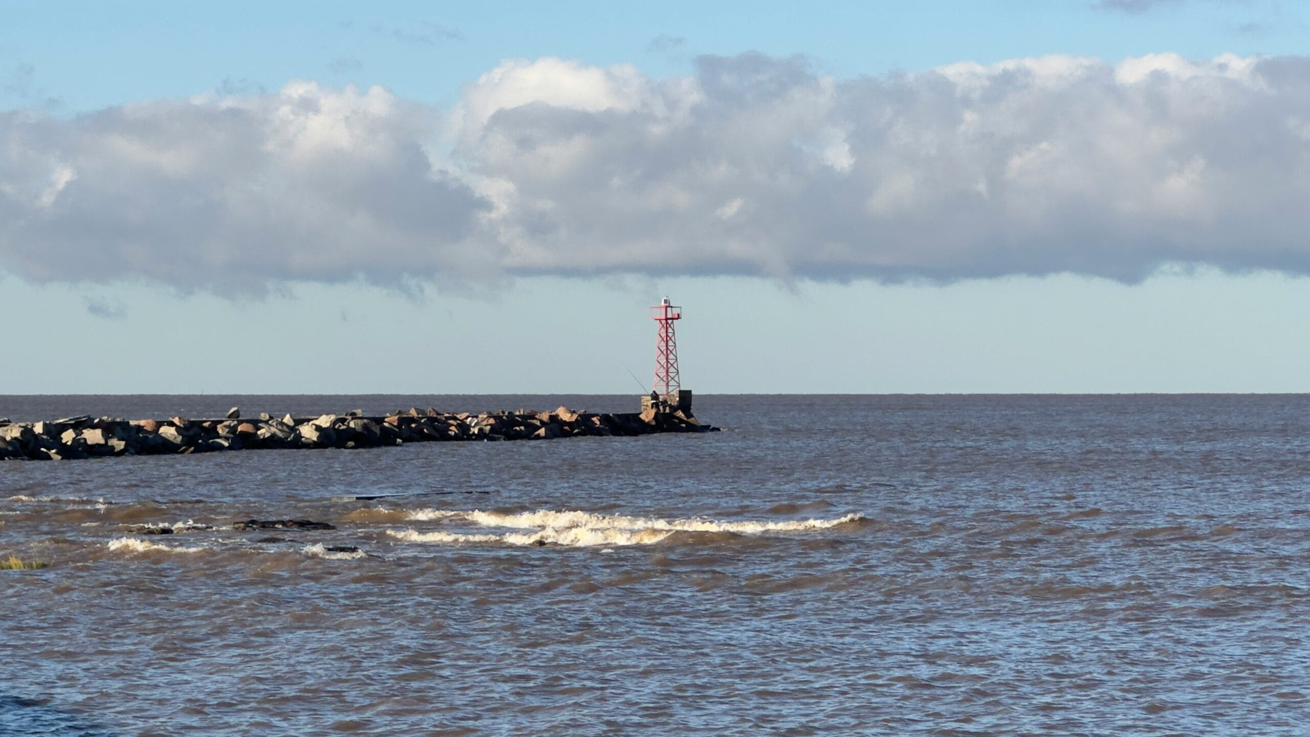 a large body of water with a lighthouse in the distance