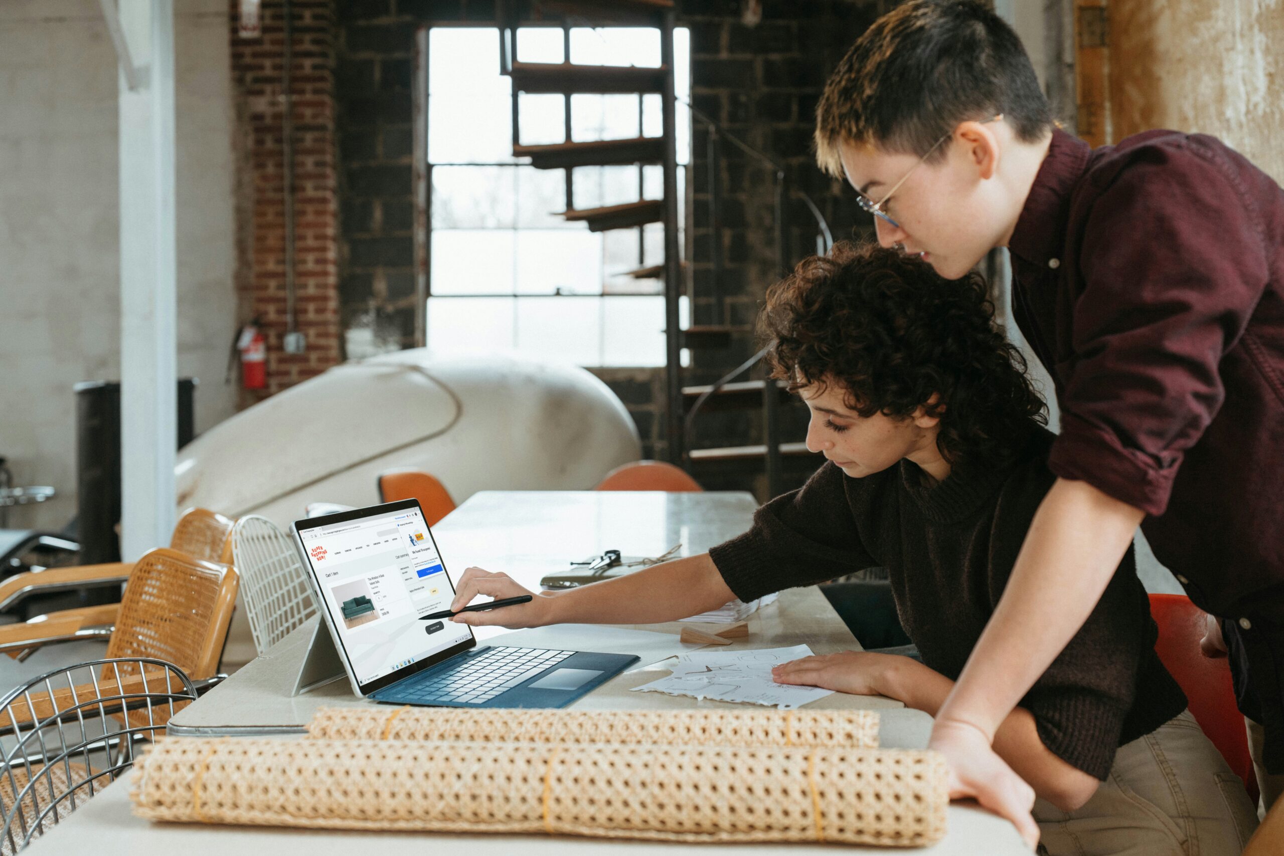 a man and a woman are looking at a laptop