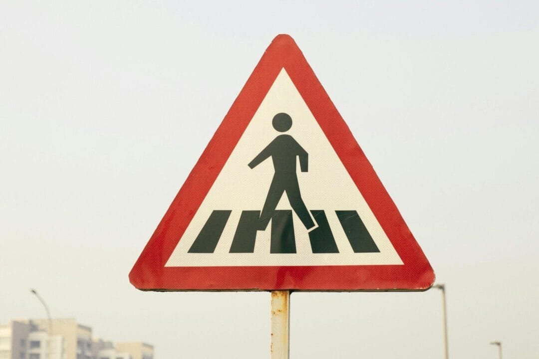 a pedestrian crossing sign on a city street