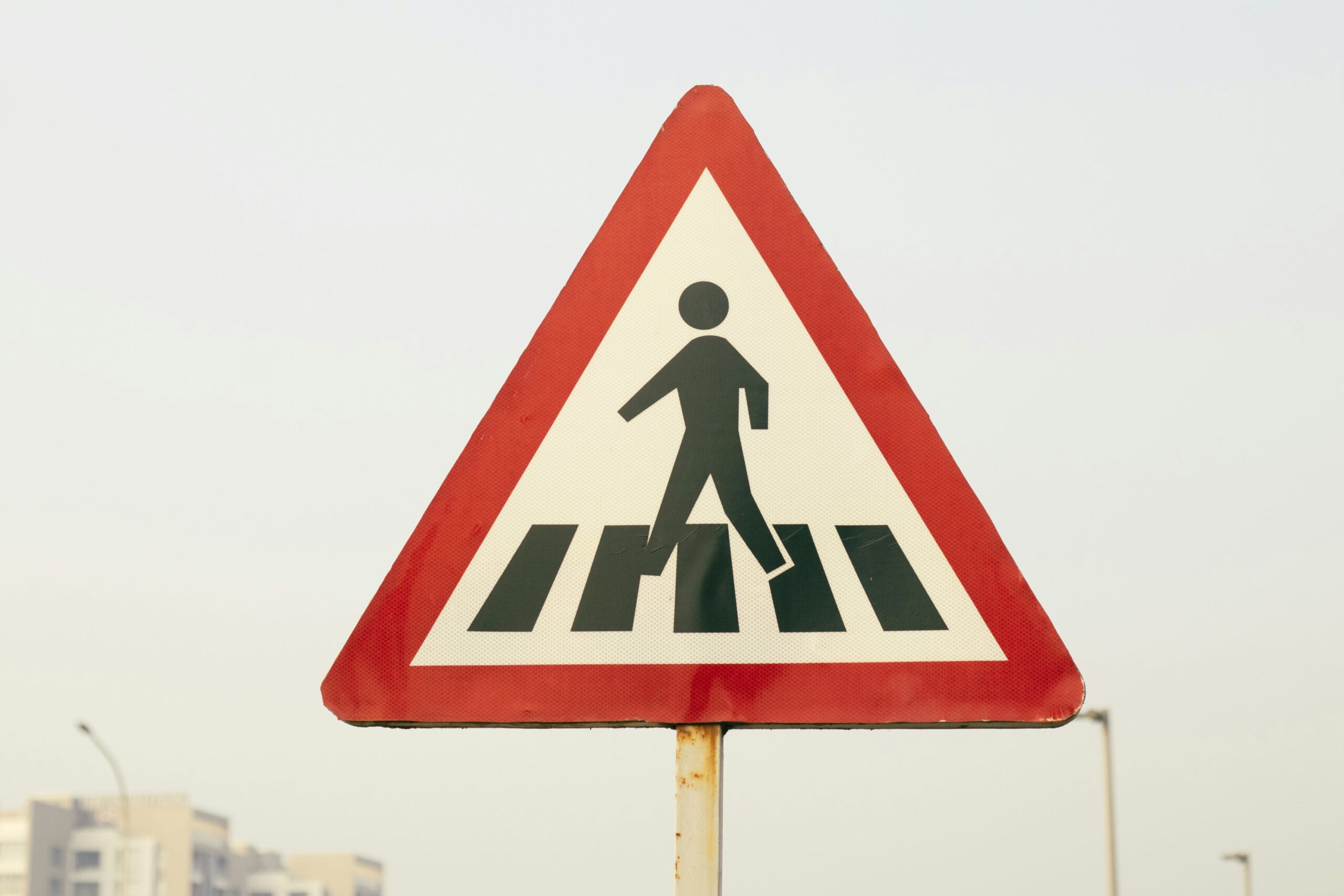 a pedestrian crossing sign on a city street