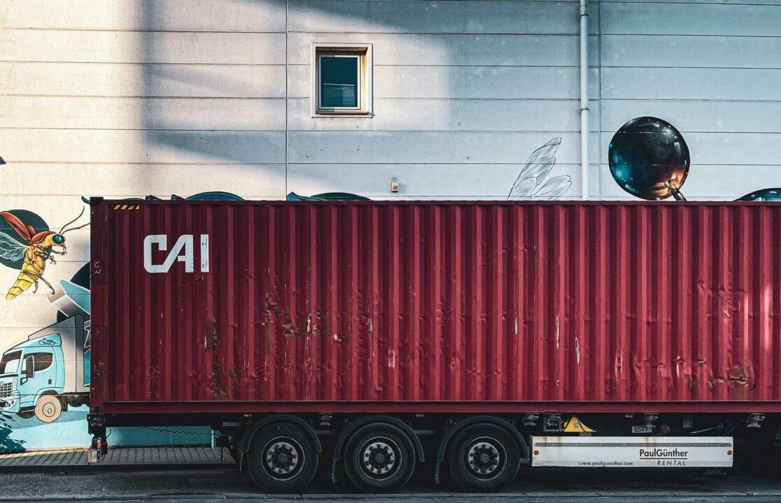 a red cargo truck parked in front of a building