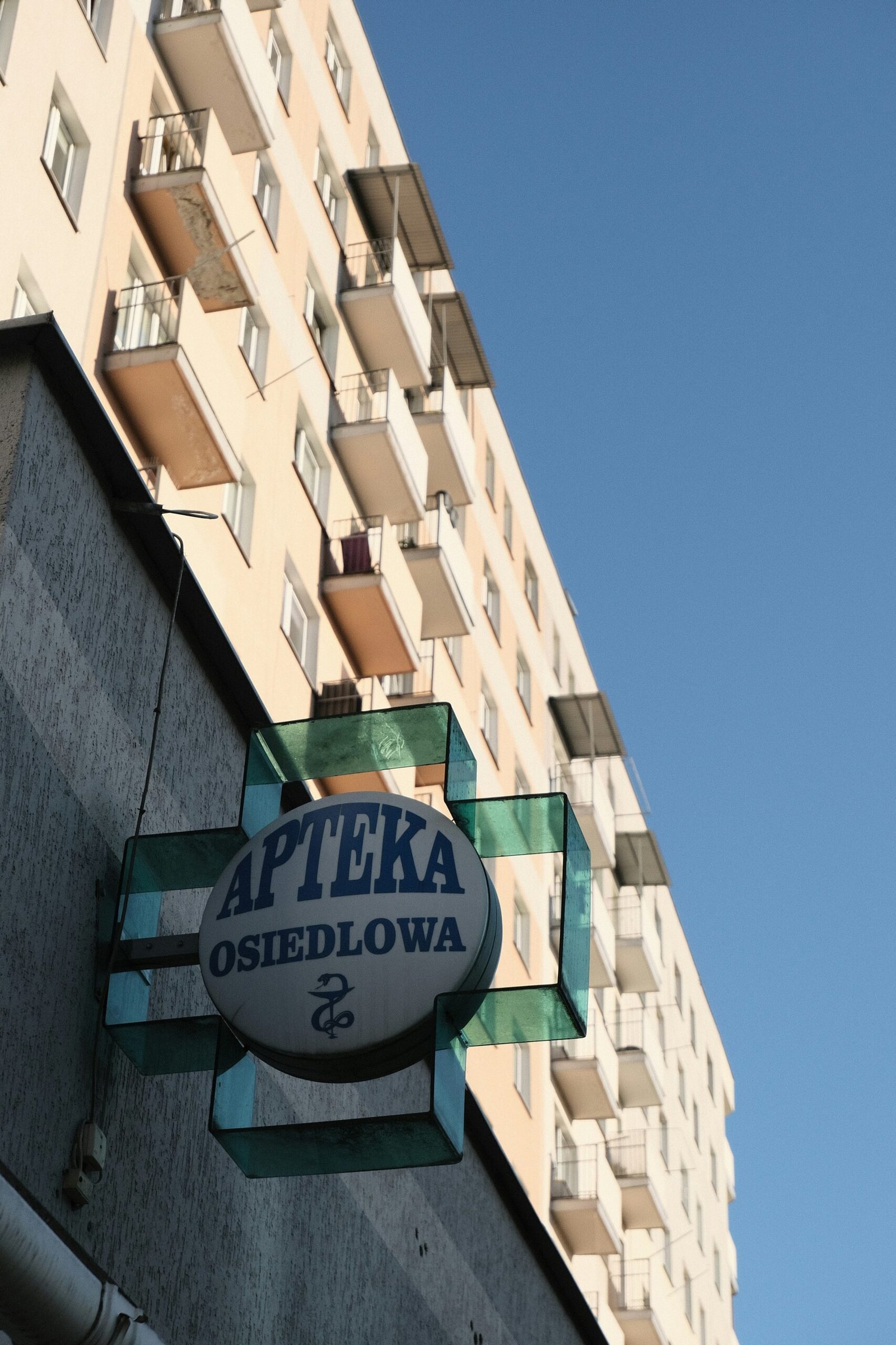 a sign on the side of a building in front of a tall building