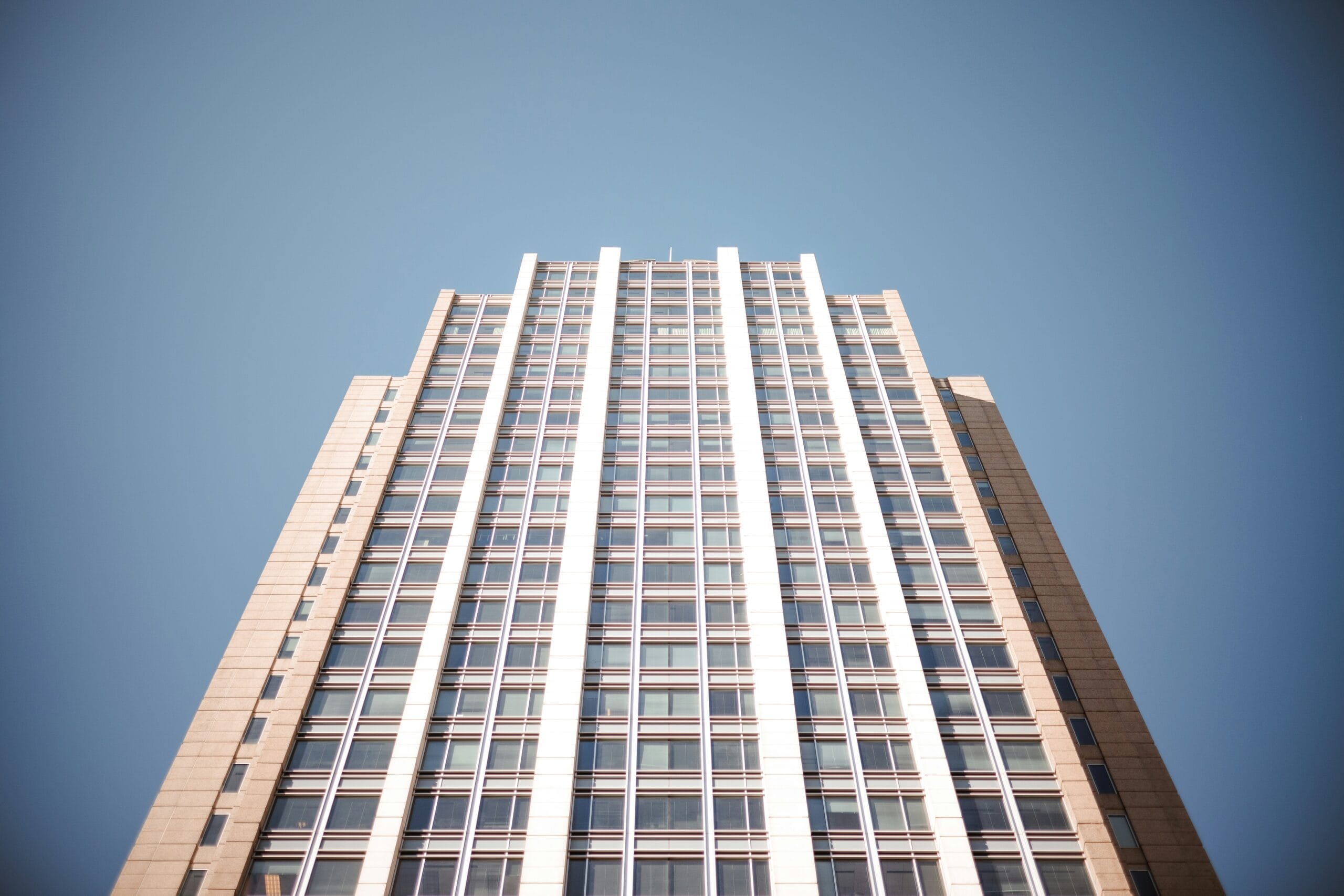 a tall building with lots of windows against a blue sky