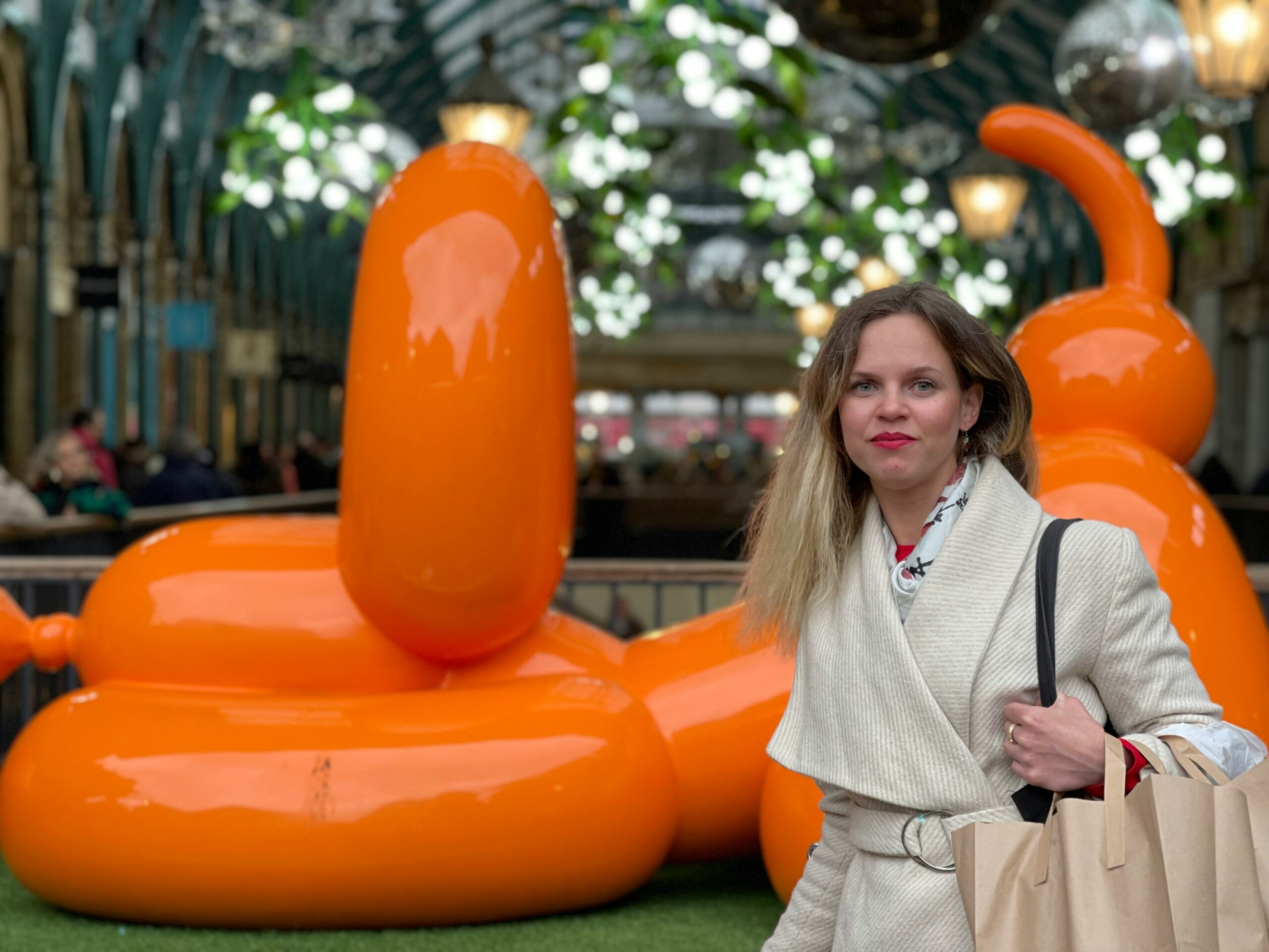 a woman is standing in front of an orange balloon