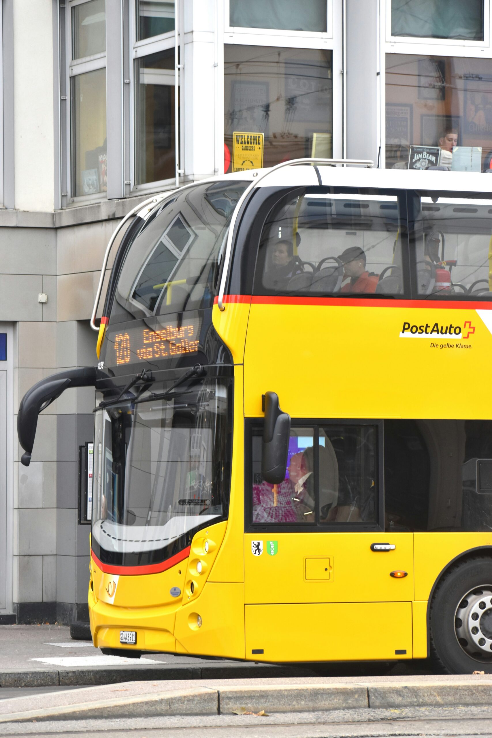 a yellow double decker bus parked in front of a building