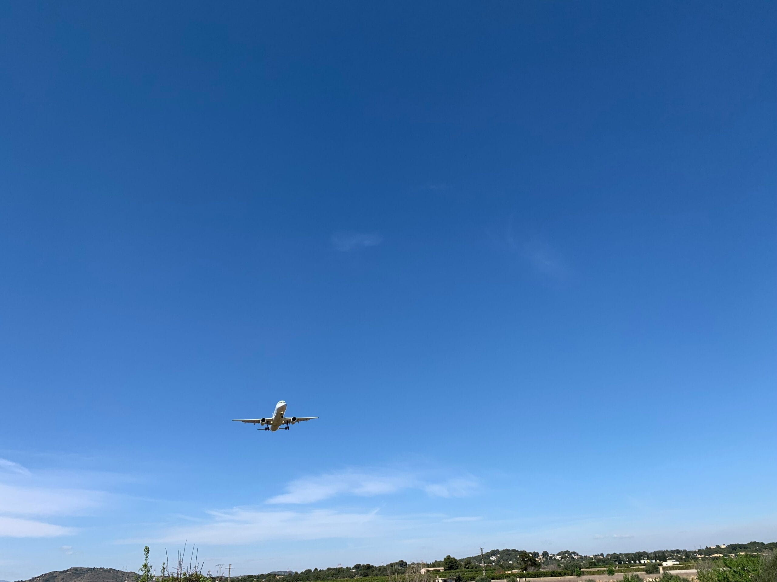 an airplane is flying in the blue sky