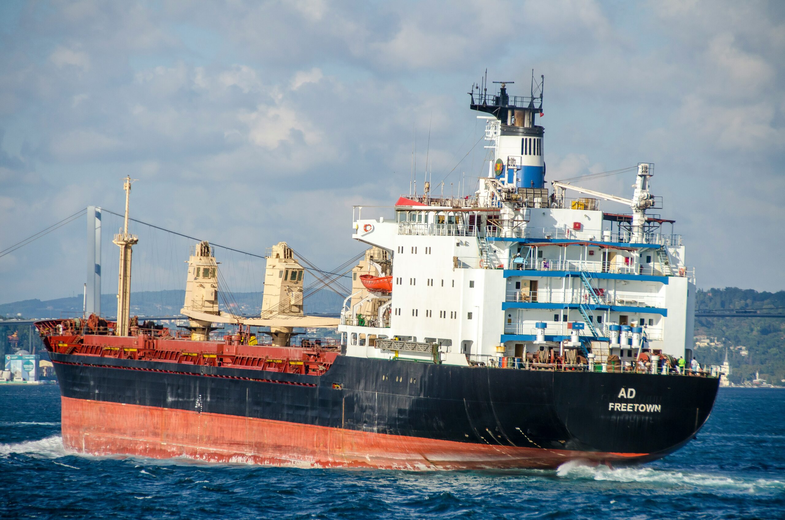 blue and white ship on sea under white clouds during daytime