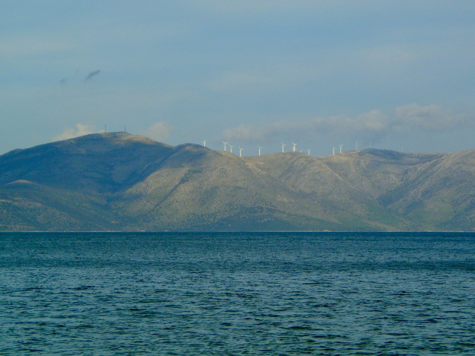 green mountains beside blue sea during daytime