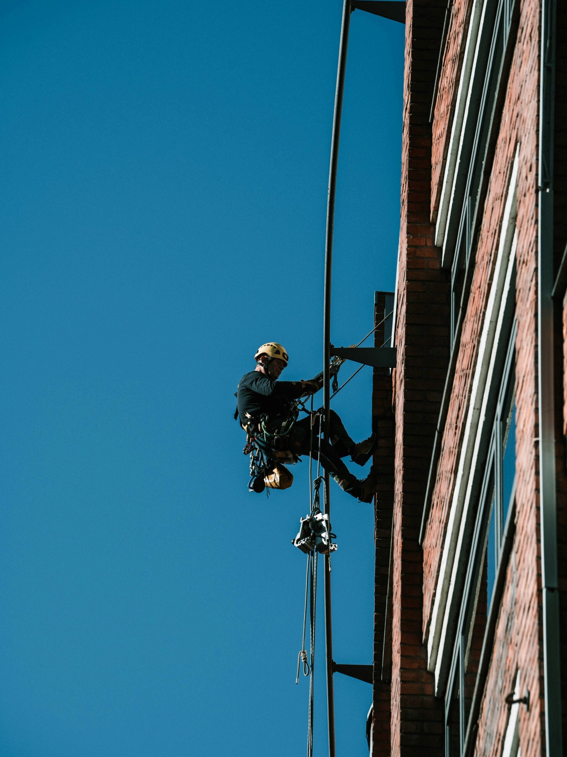 A man on a high wire working on a building