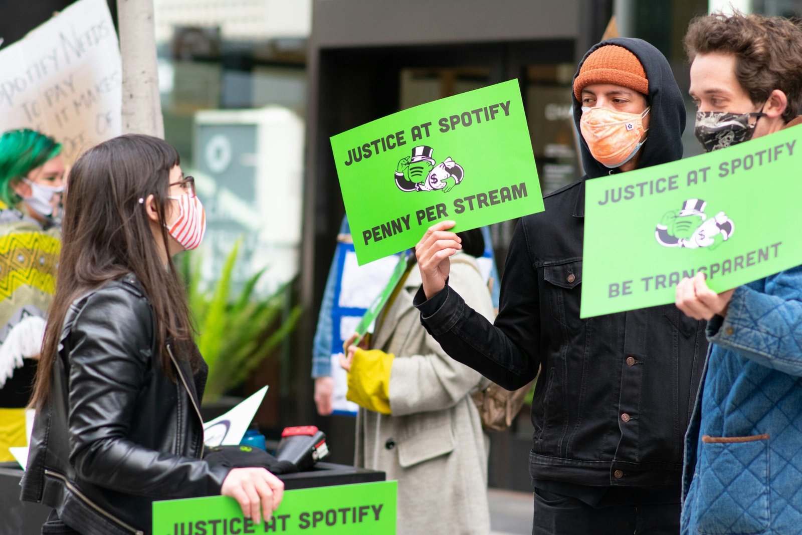 man in black jacket holding green paper