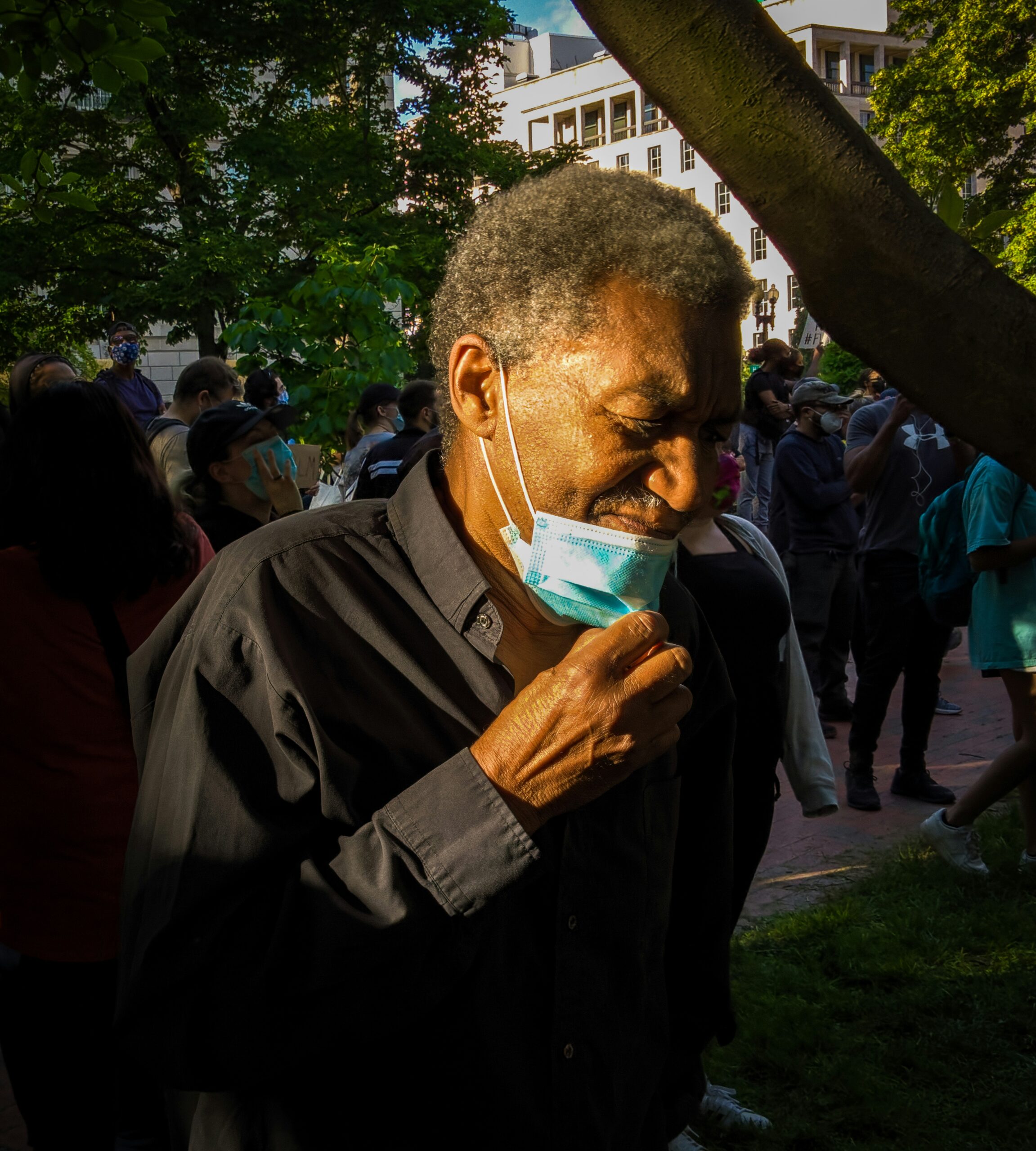 man in black jacket holding white plastic bag