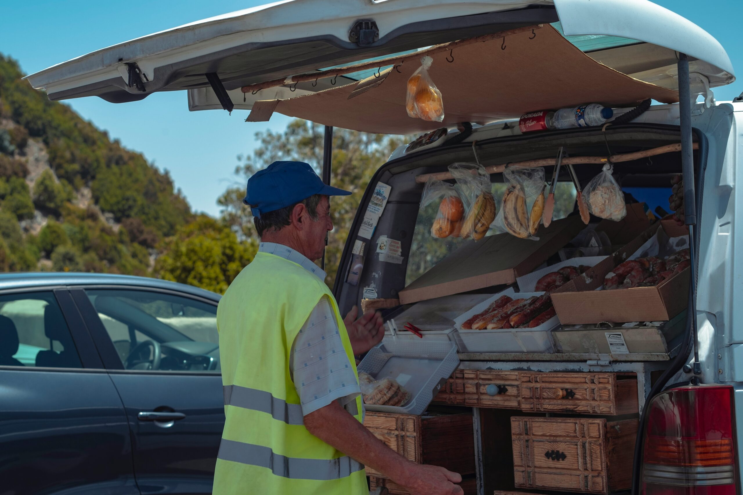 man selling food using a vehicle trunk