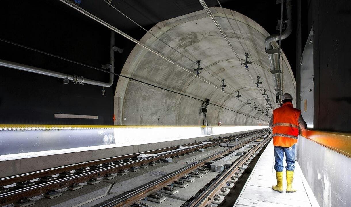 man standing beside train rail