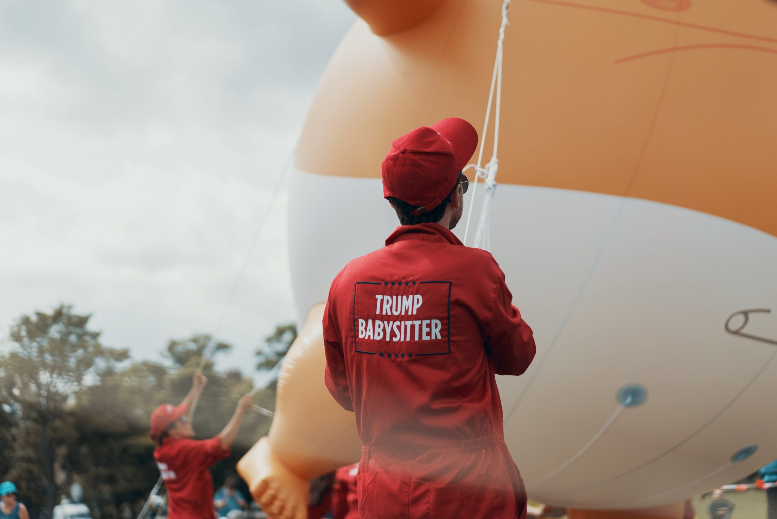 person in red cap and red long-sleeved top holding rope