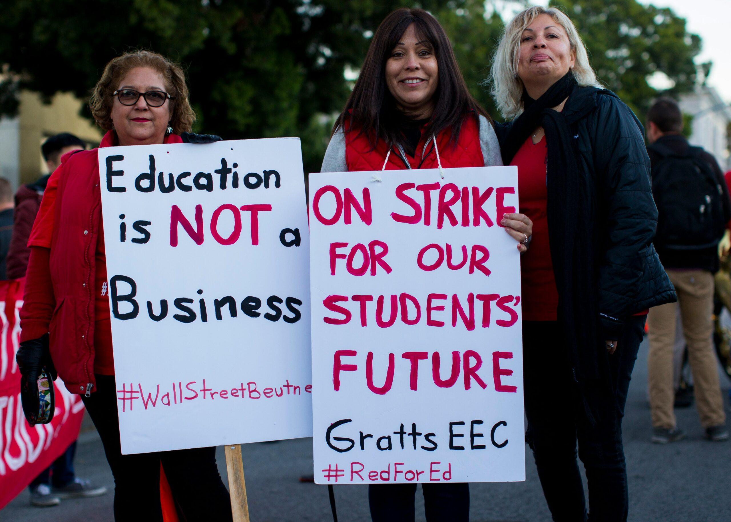 three women holding signges