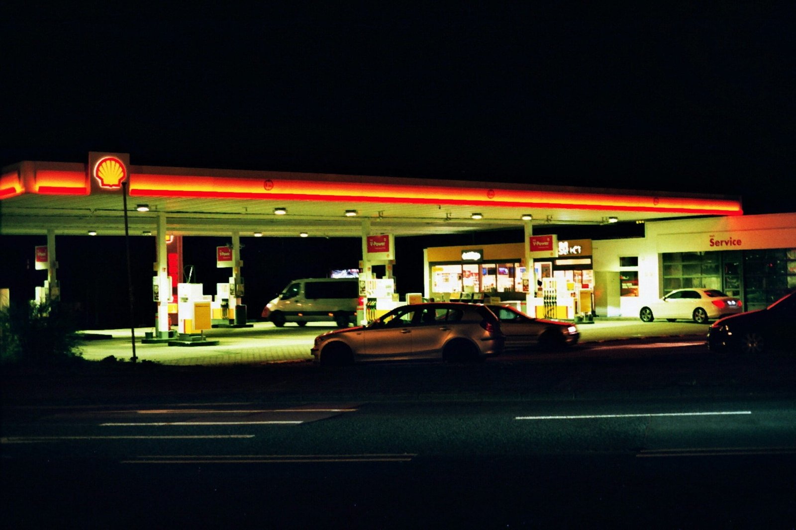 white car parked in front of store during night time