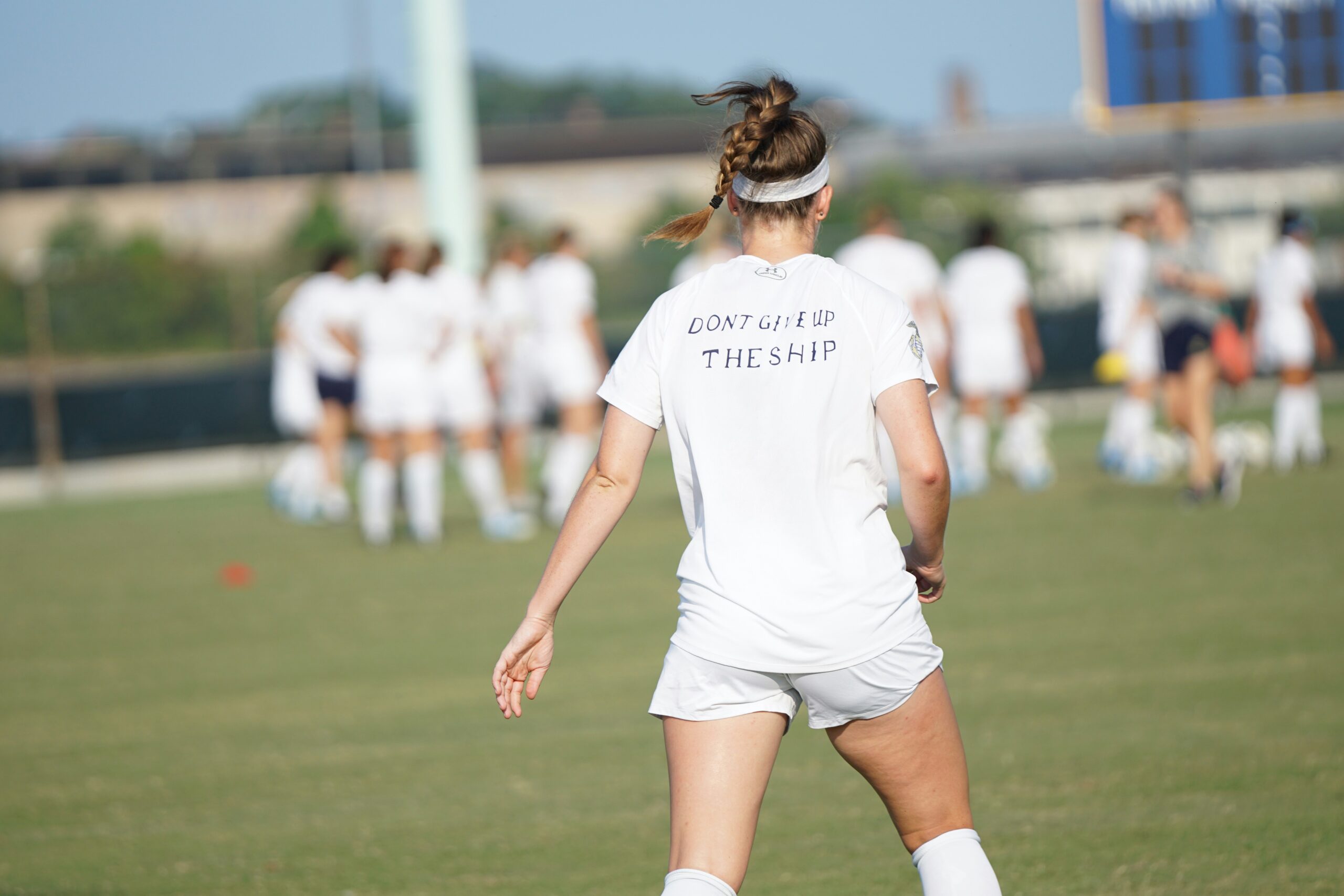 woman standing in front of women at the field during day